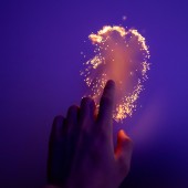 Hand touching glowing surface